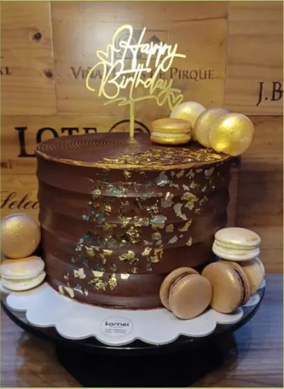 Bolo de ganache com folhas douradas e macarons