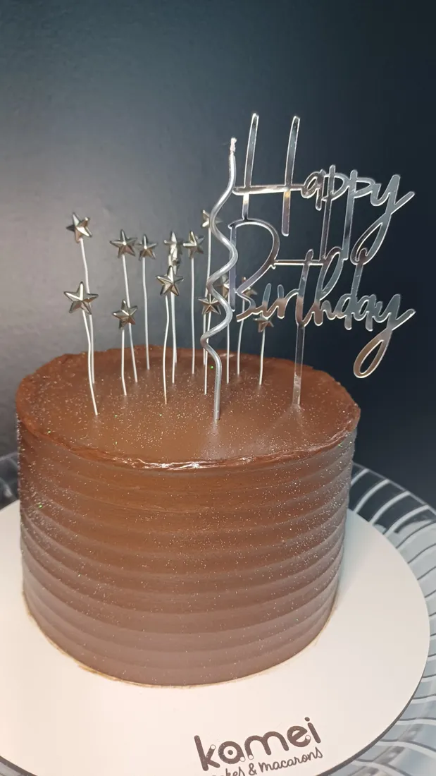 Bolo de ganache com topper Happy Birthday prata e estrelas