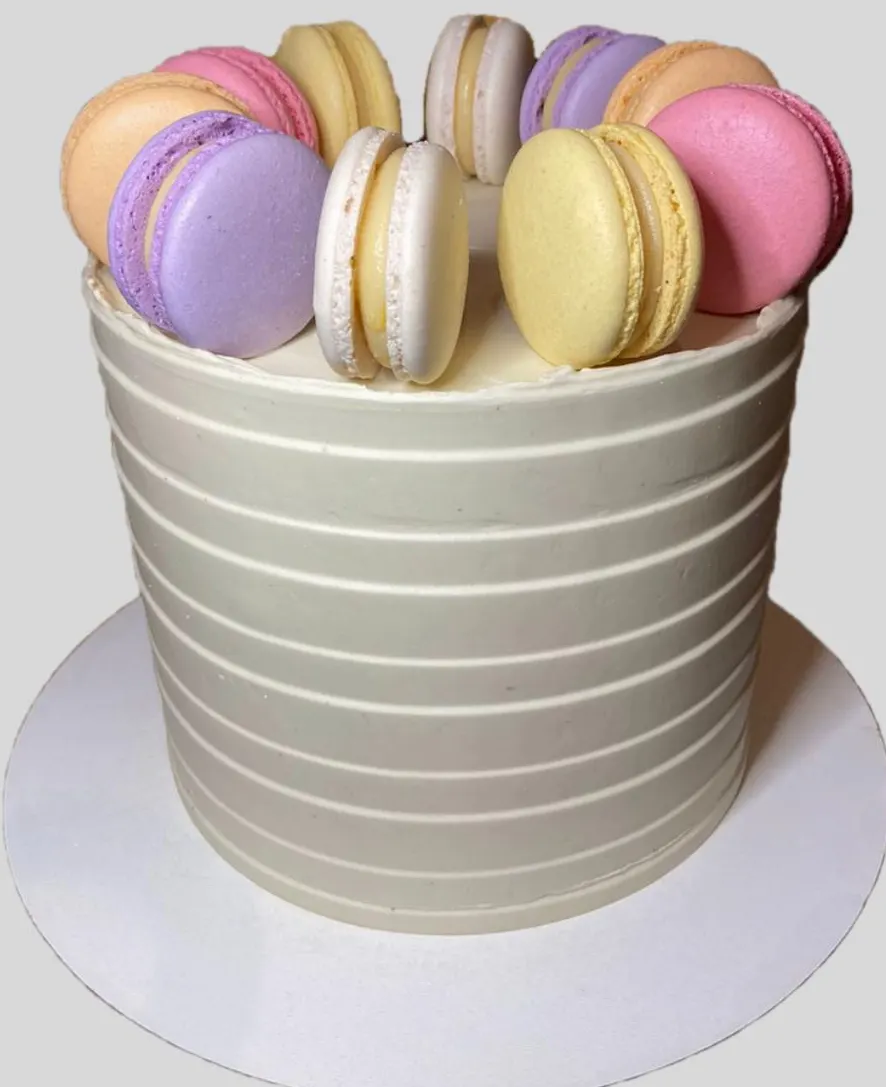Bolo de buttercream listrado com coroa de macarons coloridos